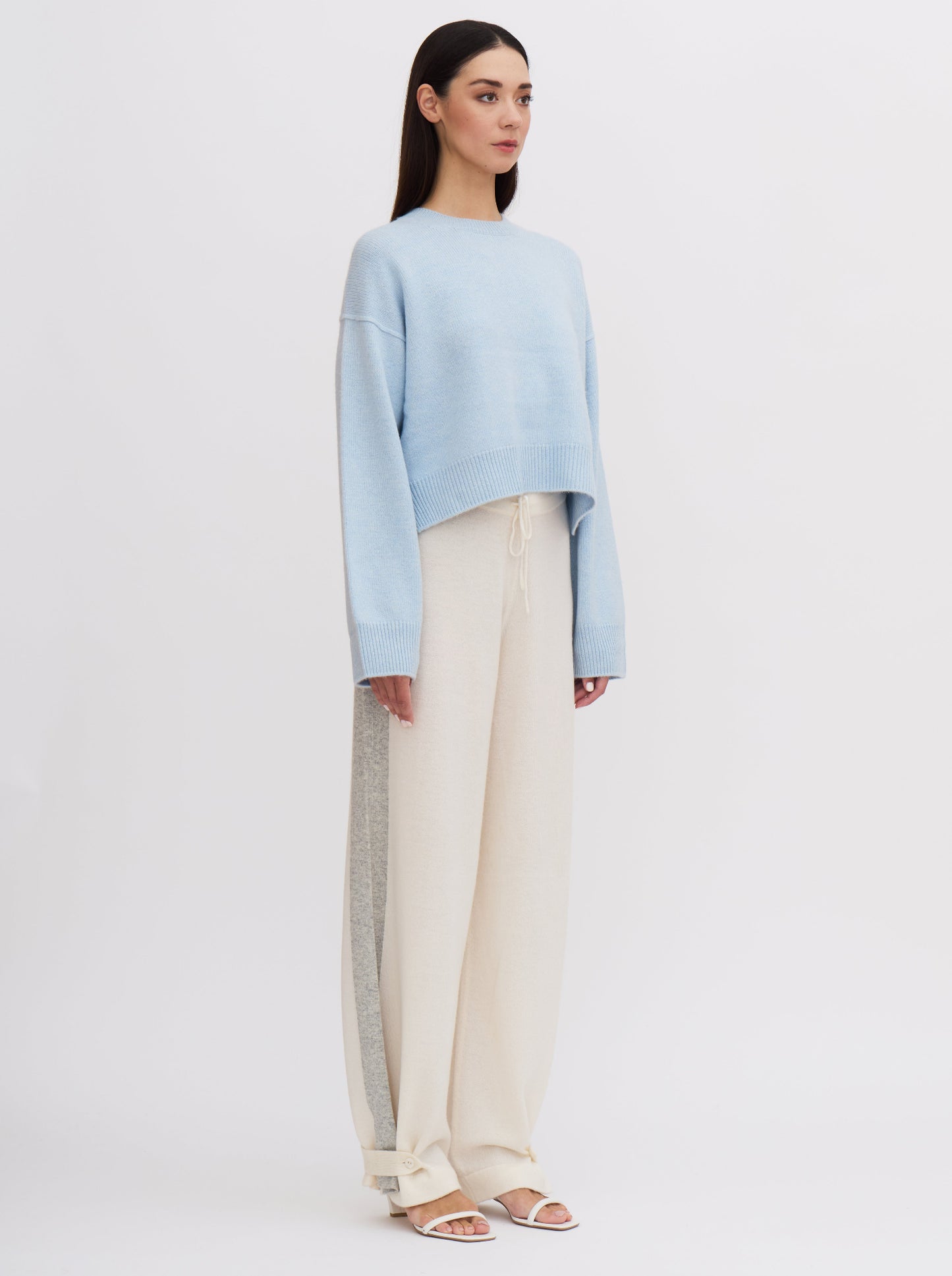 Light blue cropped cashmere sweater with cream trousers featuring grey side stripe.
