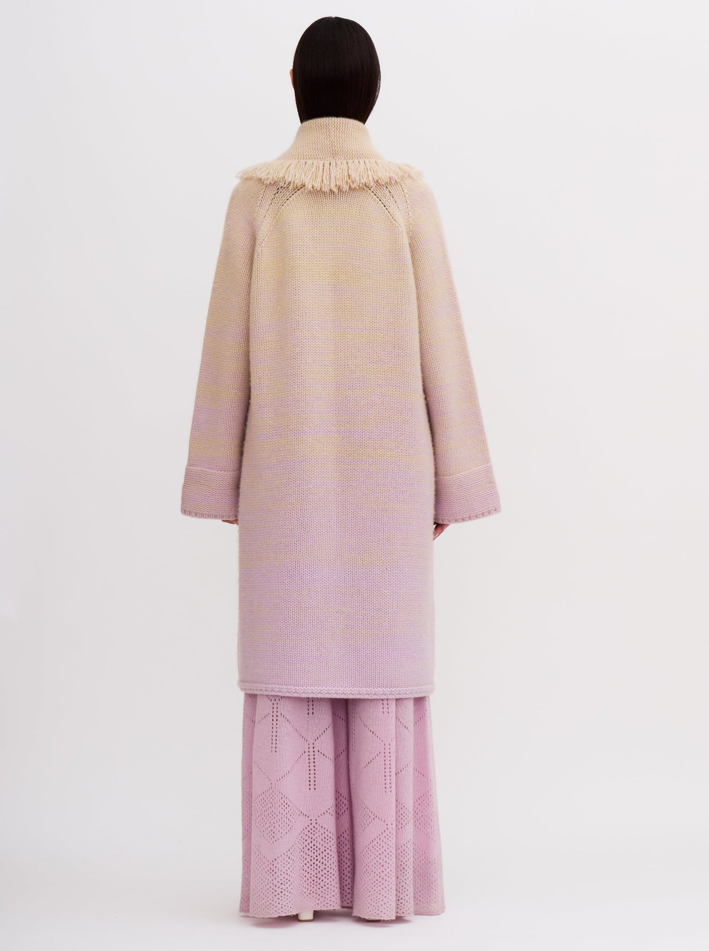 Light pink cashmere robe coat with fringe detailing, worn with matching pink knitted pants