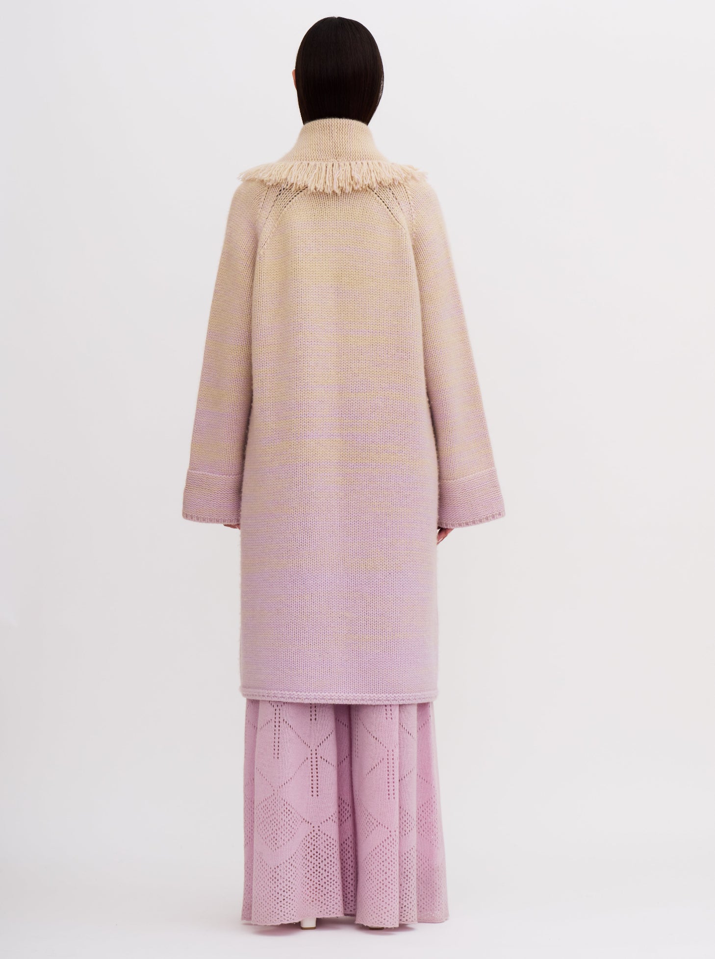 Light pink cashmere robe coat with fringe detailing, worn with matching pink knitted pants