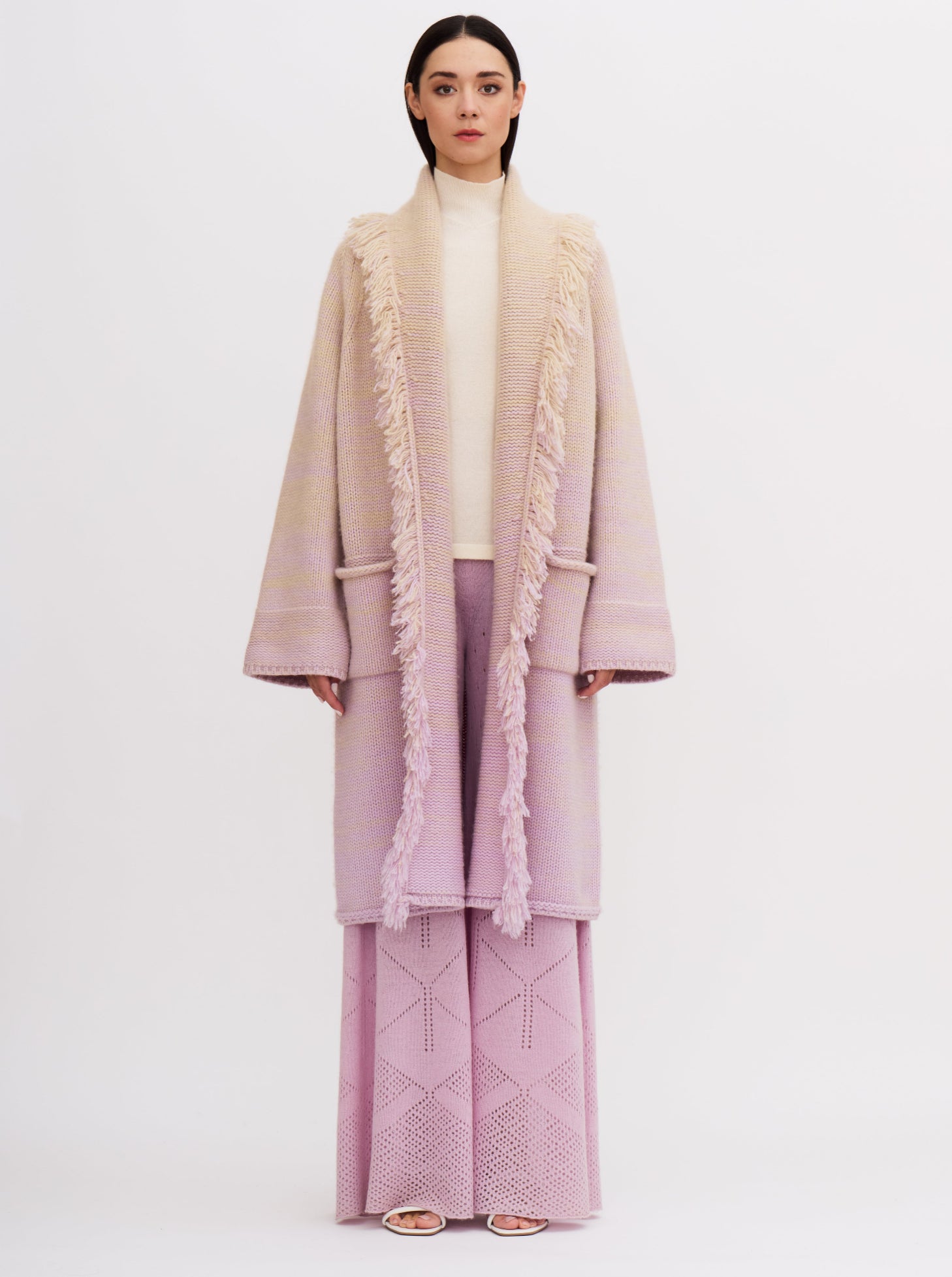 Light pink cashmere robe coat with fringe detailing, worn with matching pink knitted pants