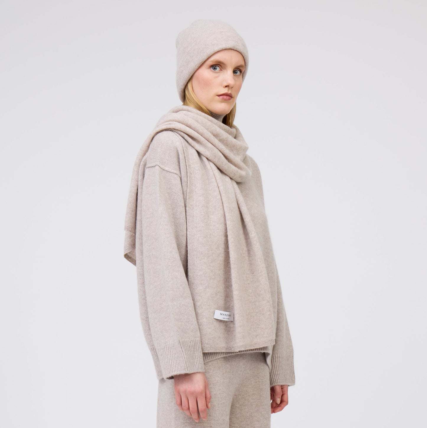 Modal wears pale beige cashmere scarf with matching beige beanie and cashmere jumper.