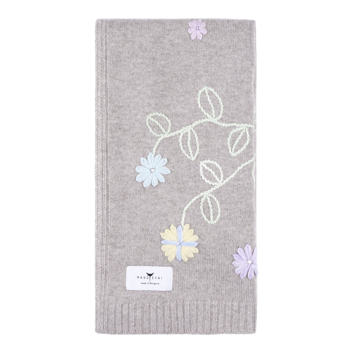 Beige knitted cashmere, square baby cost blanket, covered in pastel coloured hand embroidery of flowers and leaves.
