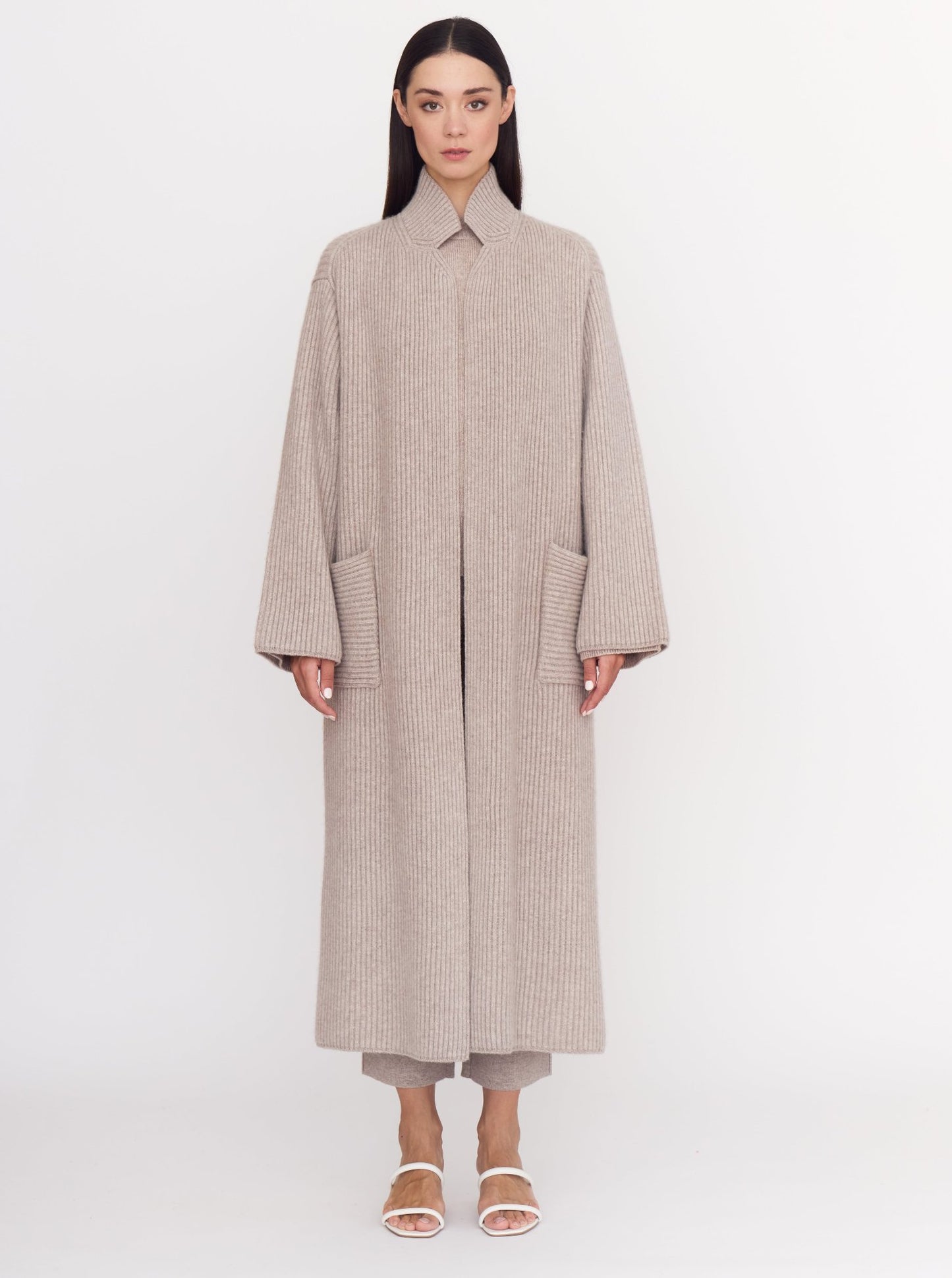 Front view of model wearing cool beige shade of ribbed cashmere knit long coat.