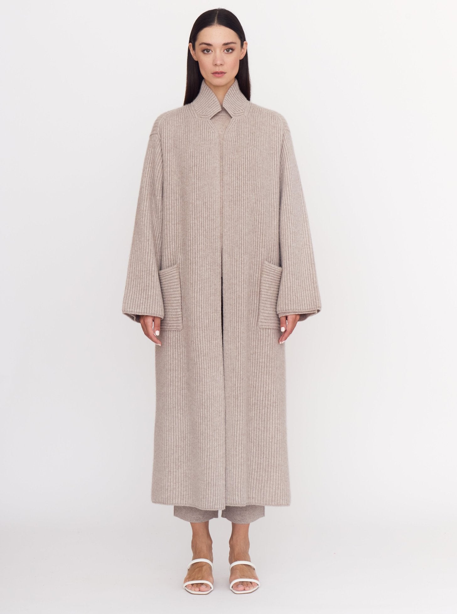 Front view of model wearing cool beige shade of ribbed cashmere knit long coat.