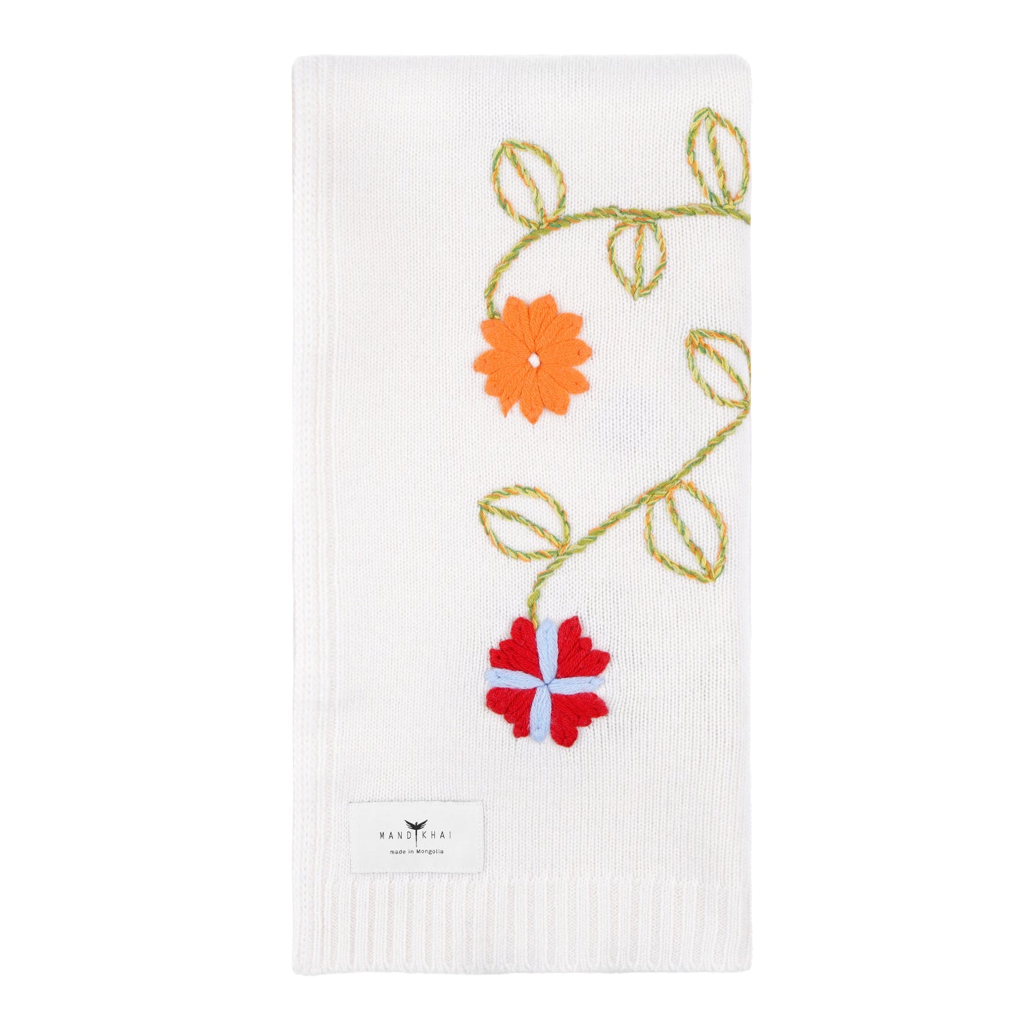 White knitted cashmere, square, baby cot blanket with a brightly coloured hand embroidery of flowers and leaves.