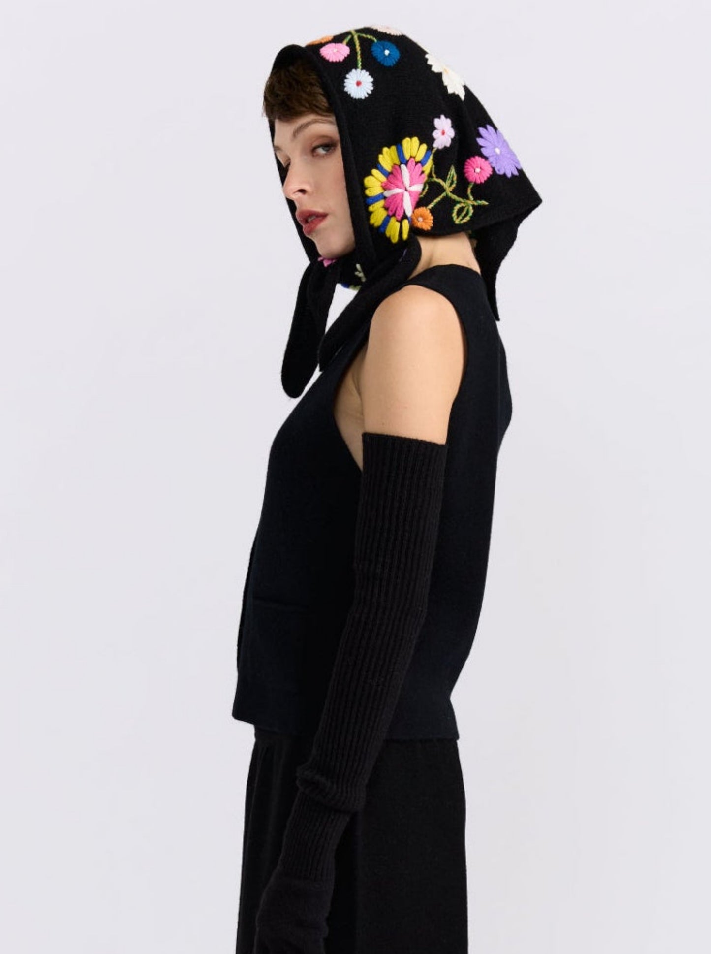 Model wearing the MANDKHAI black embroidered triangle cashmere scarf styled as a headscarf.