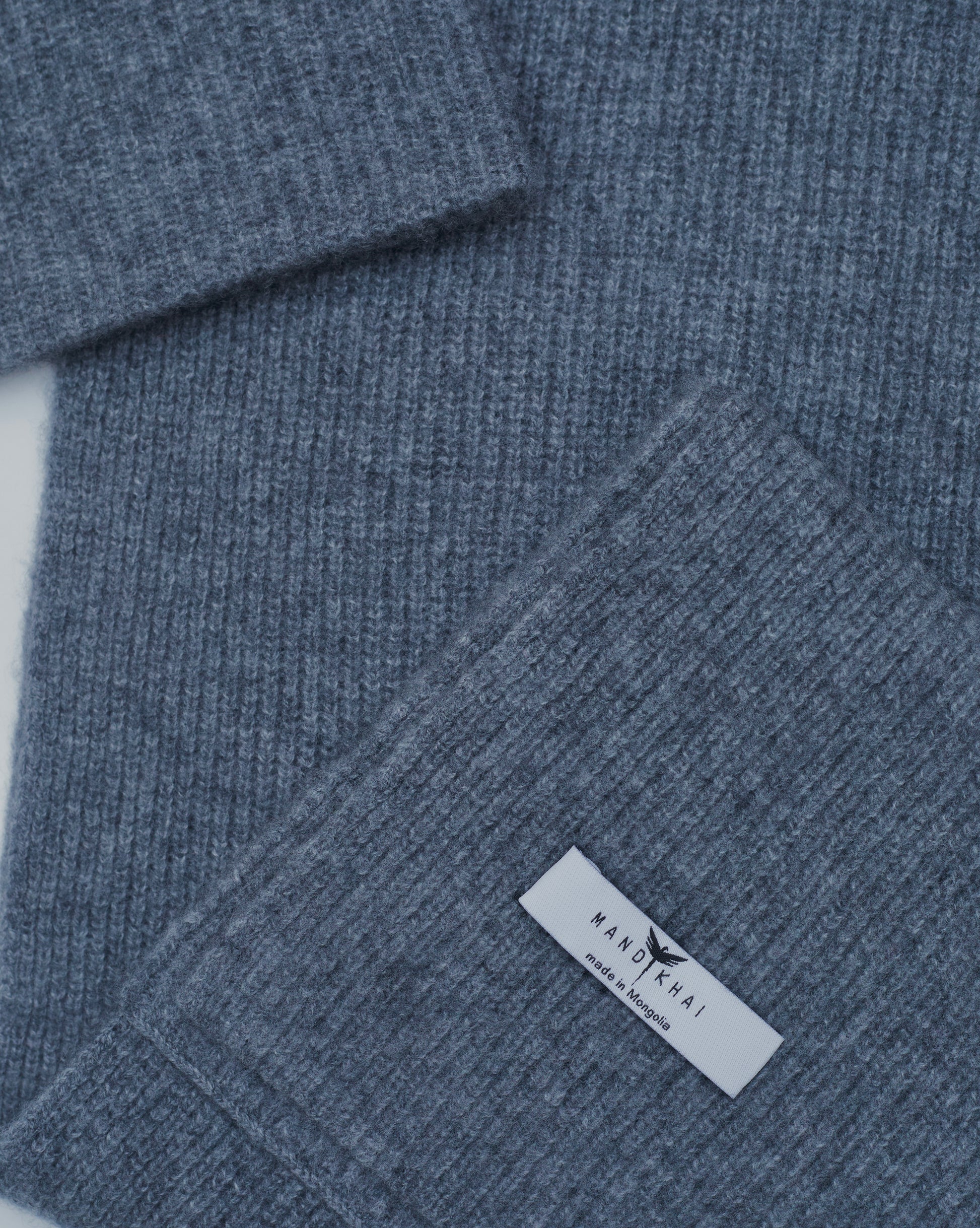 flat lay close up of grey cashmere ribbed knit scarf and hat set with mandkhai label detail