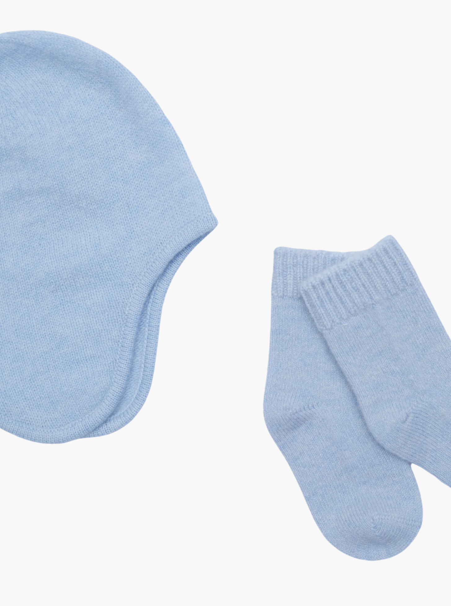 close up flat lay of the light blue cashmere baby hat and socks set