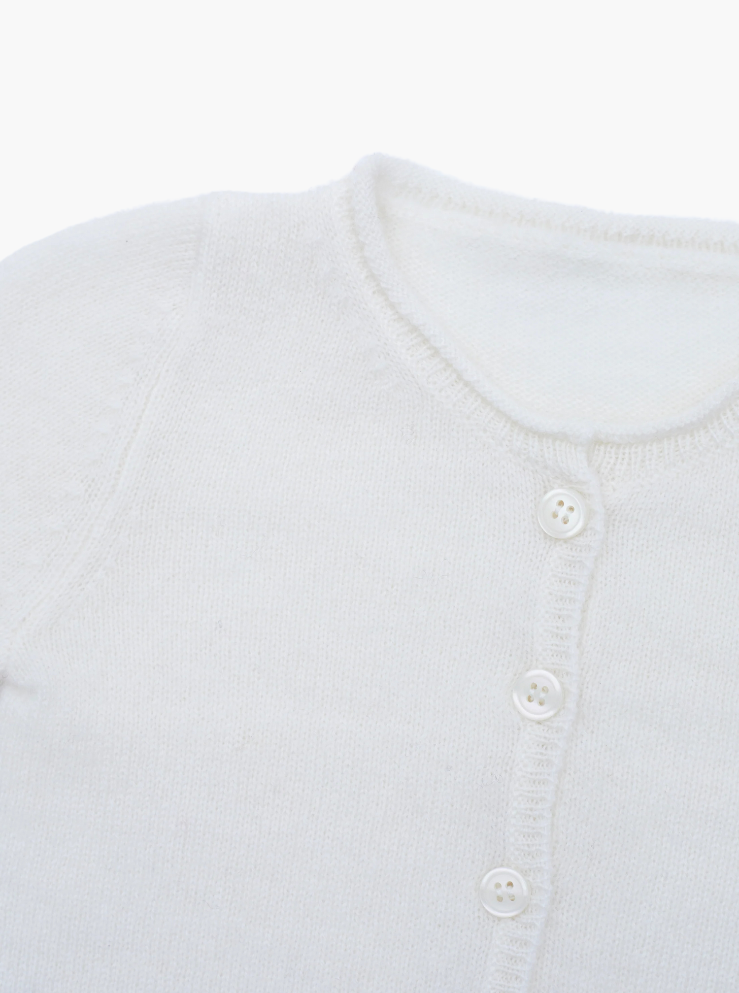 Close up button detail of the white baby cashmere cardigan
