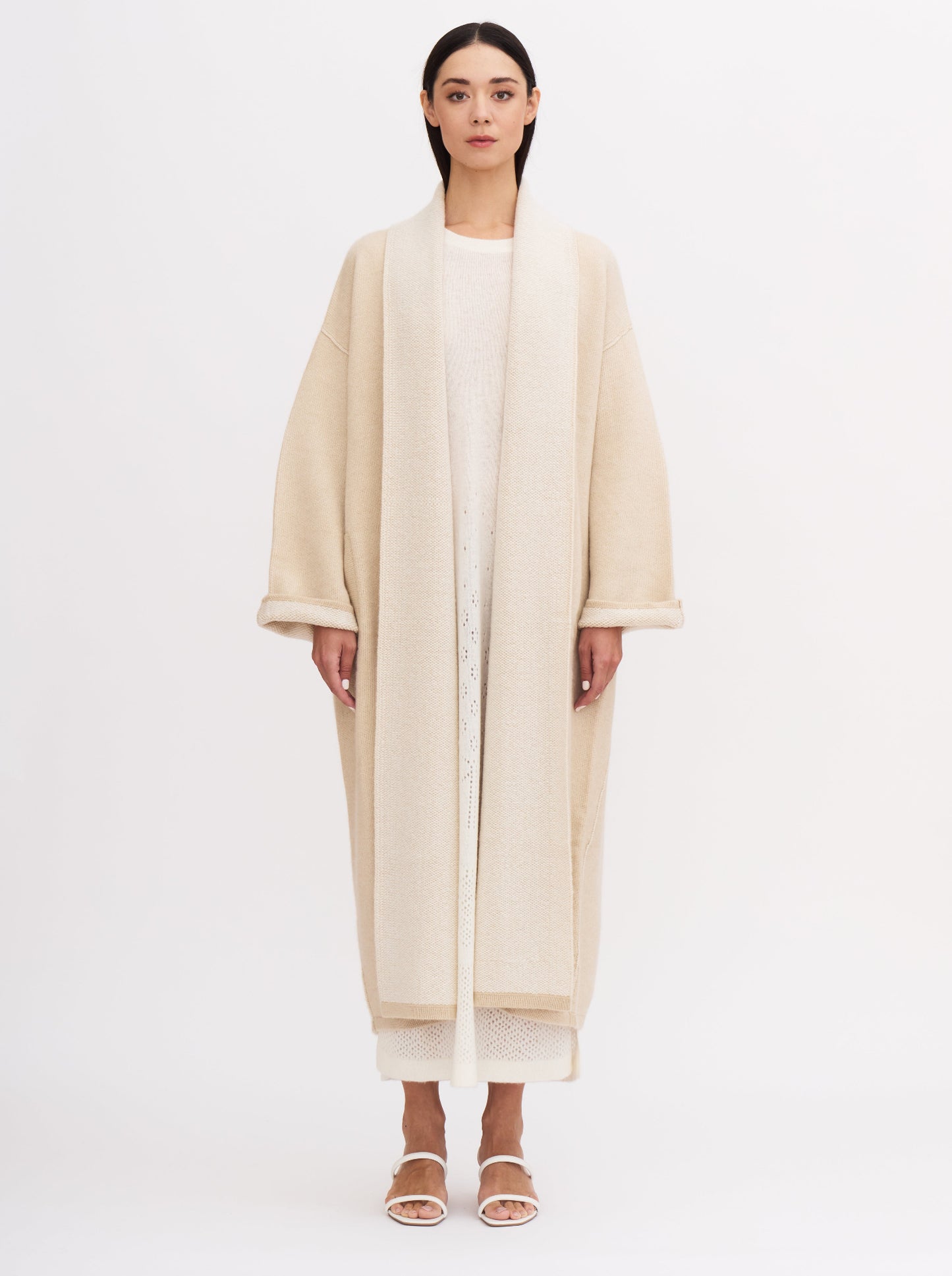 Long beige balloon-shaped cashmere coat with a two-tone design and relaxed fit, featuring a shawl collar and wide sleeves.