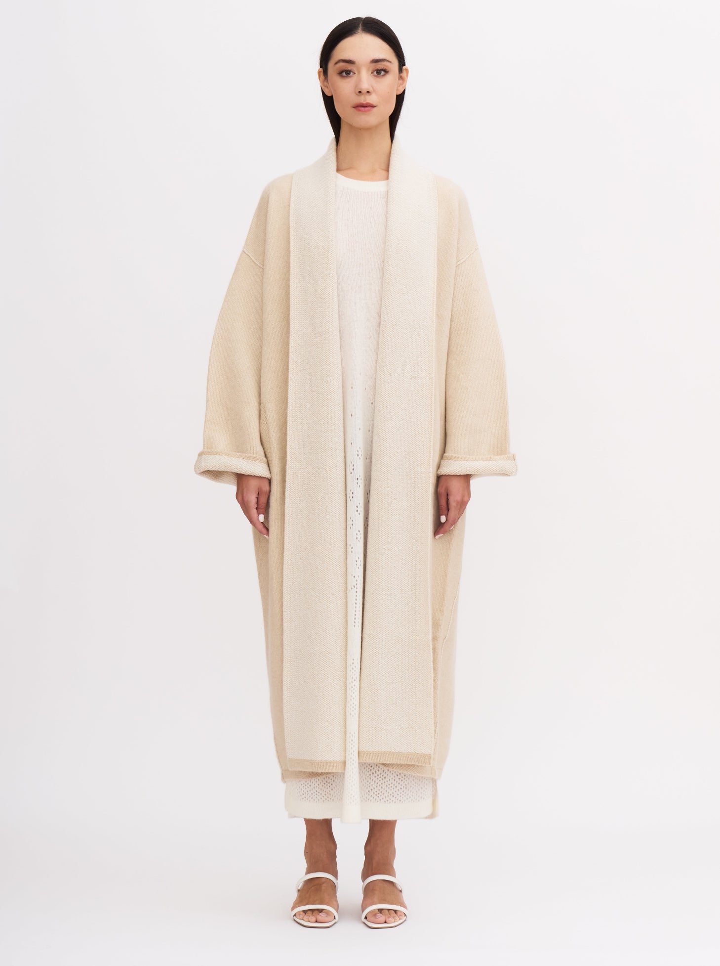 Long beige balloon-shaped cashmere coat with a two-tone design and relaxed fit, featuring a shawl collar and wide sleeves.