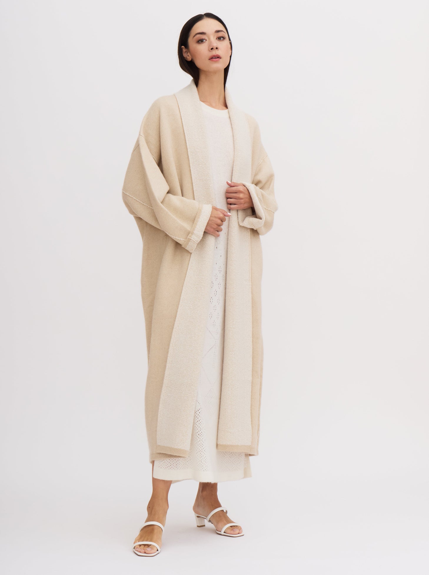 Long beige balloon-shaped cashmere coat with a two-tone design and relaxed fit, featuring a shawl collar and wide sleeves.