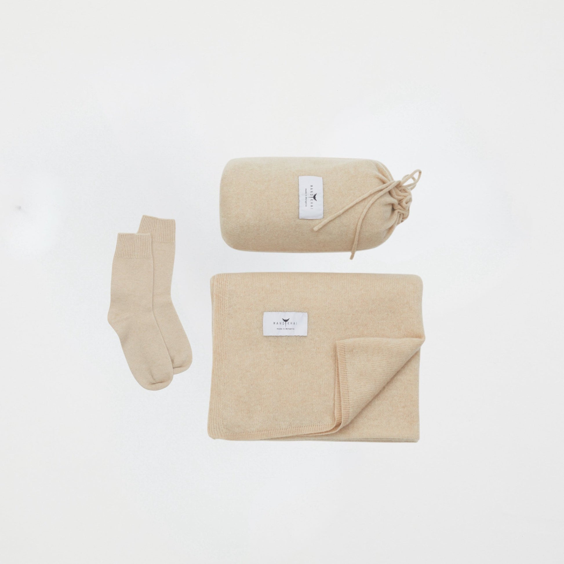 front flat lay of the beige cashmere shawl with travel pouch and ankle socks set 