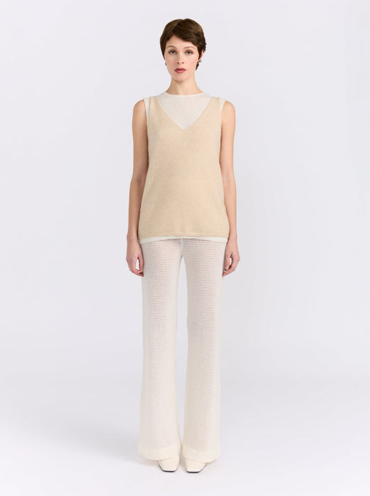 Model wearing the MANDKHAI beige and white double-layer cashmere vest with cream wide-leg trousers.