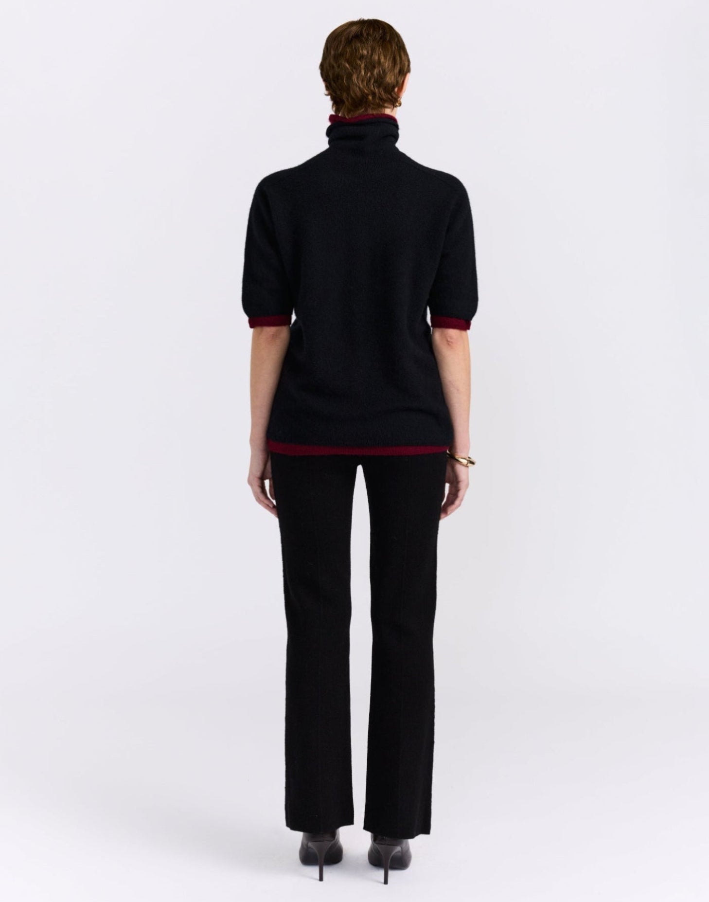 Black and burgundy cashmere sweater on model.