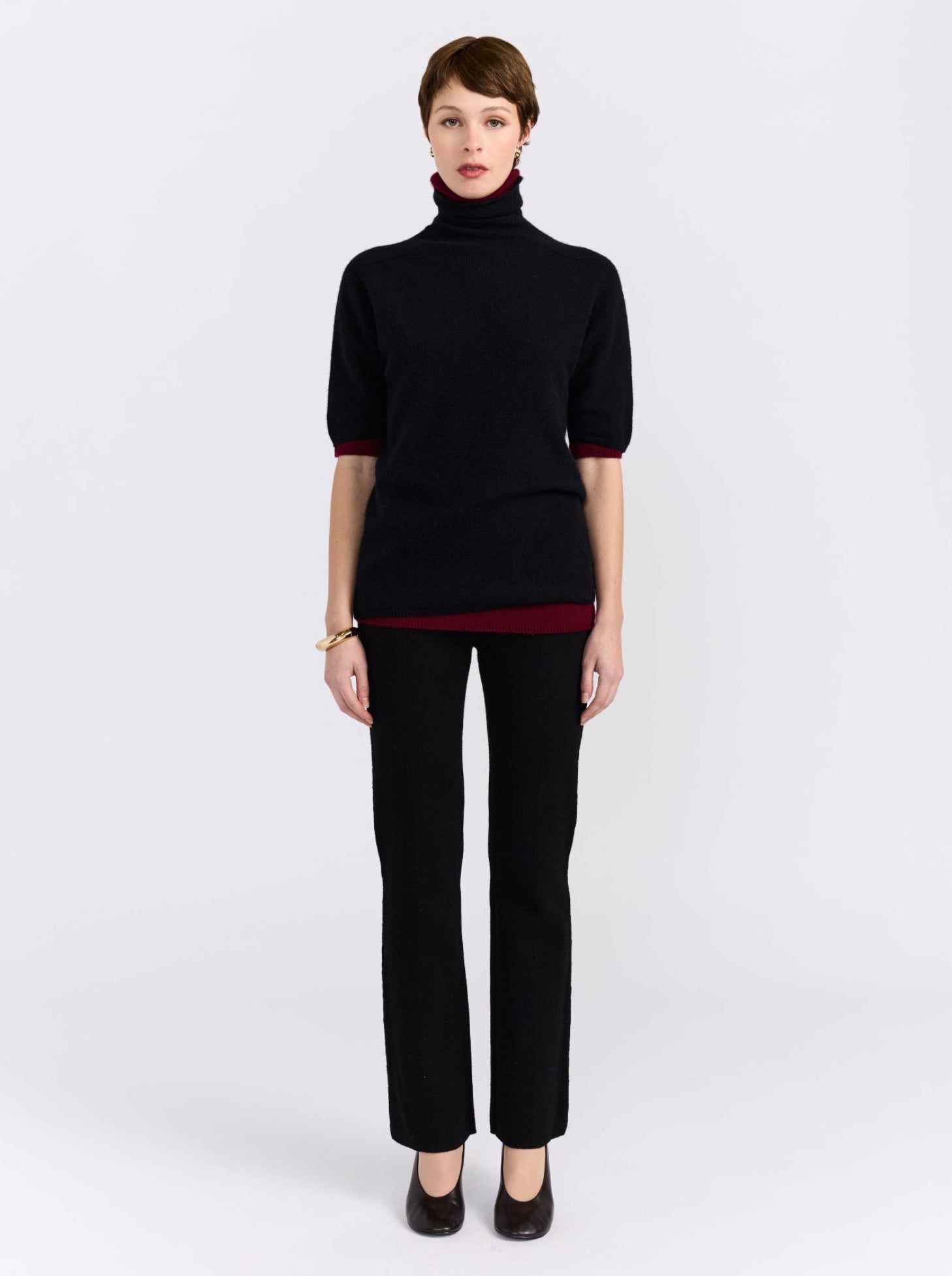 Black and burgundy cashmere sweater on model.
