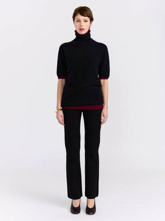 Black and burgundy cashmere sweater on model.