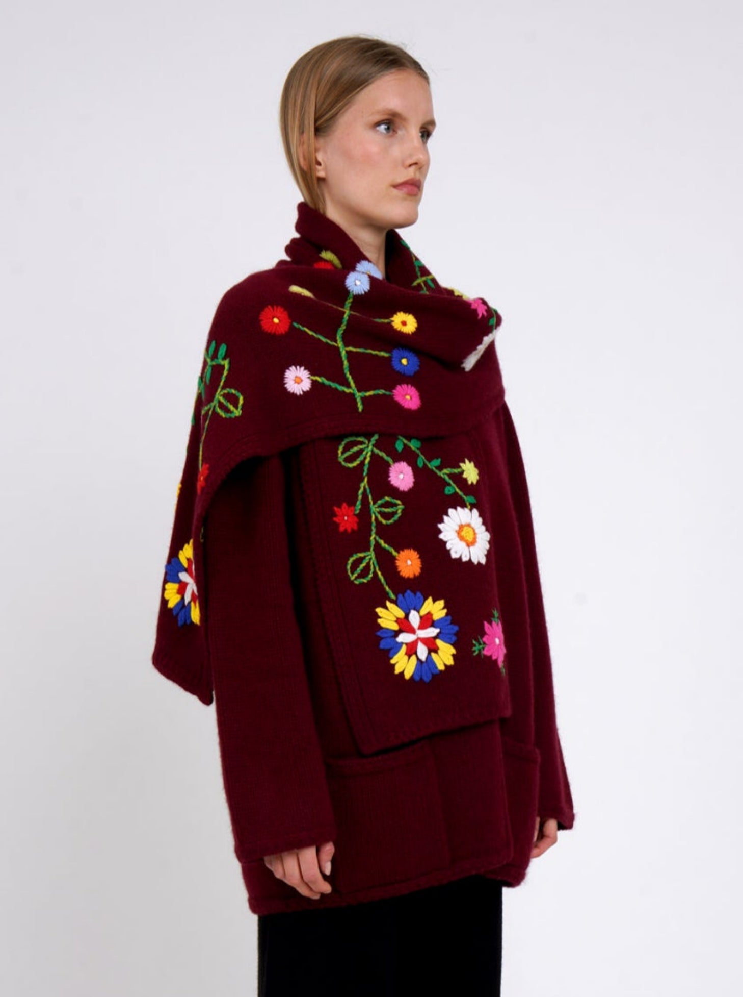 Side view burgundy cashmere hip length jacket with a colourful flower embroidered detachable scarf.