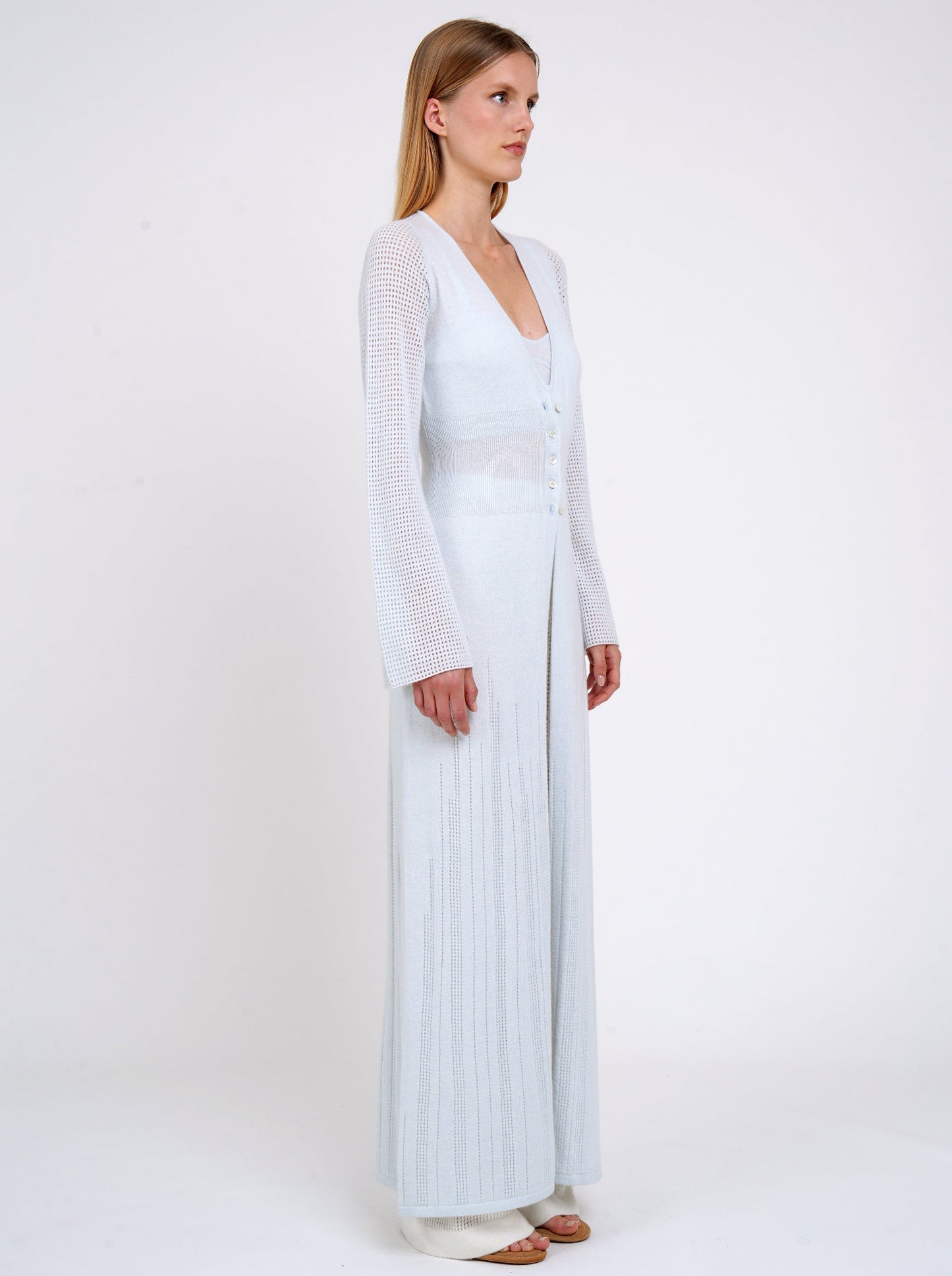 side view model in maxi-length long fitted light knit cashmere cardigan in pale blue with deep V neck, long sleeves, buttons through waist.