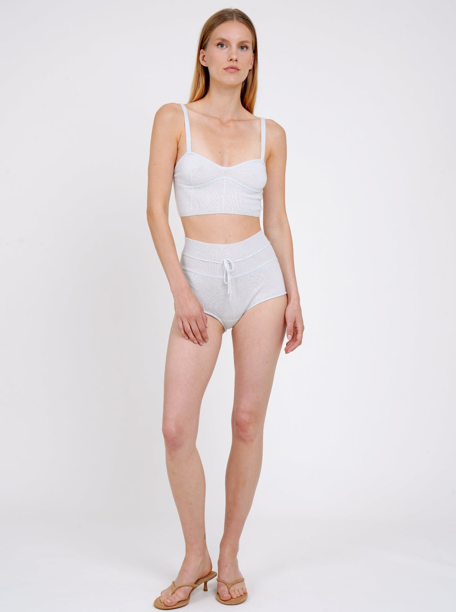 Front view model standing in pale blue knit cropped bra top and matching blue cashmere knit shorts with drawstring waist.