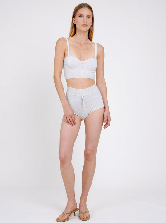 Front view model standing in pale blue knit cropped bra top and matching blue cashmere knit shorts with drawstring waist.