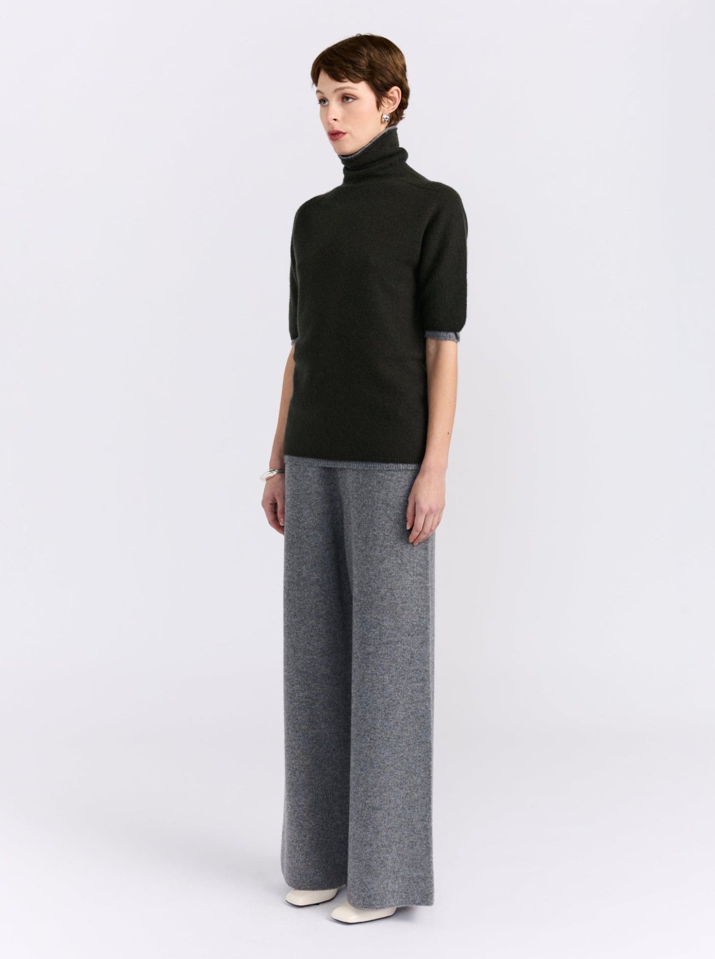 A model wears a cashmere double layer khaki and grey short sleeve sweater. 