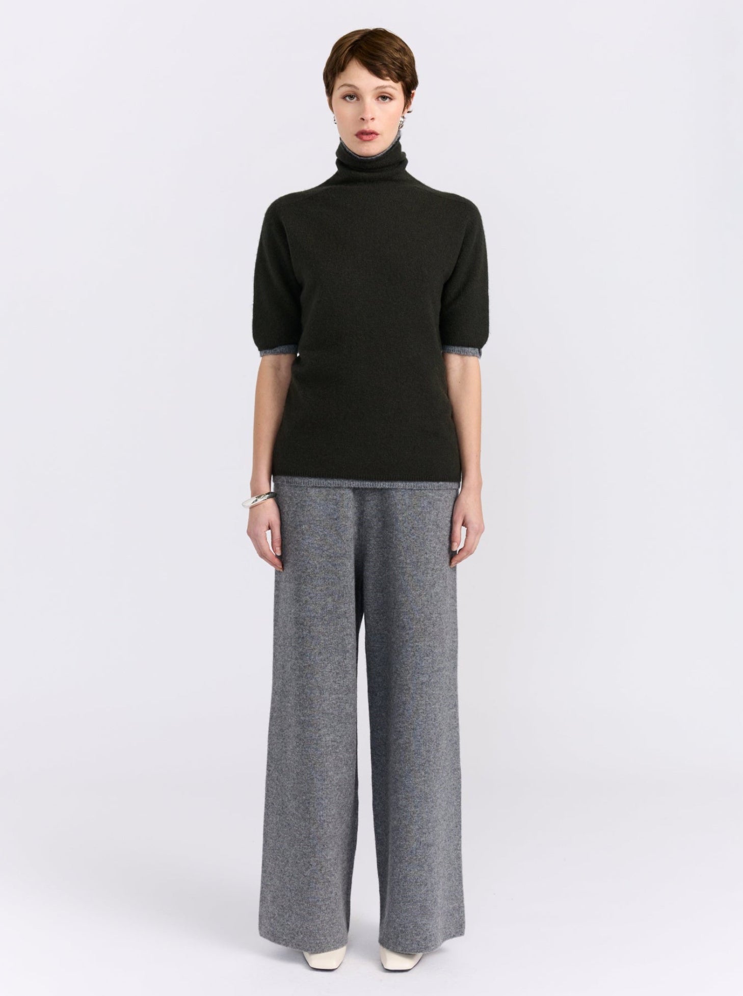 A model wears a cashmere double layer khaki and grey short sleeve sweater. 