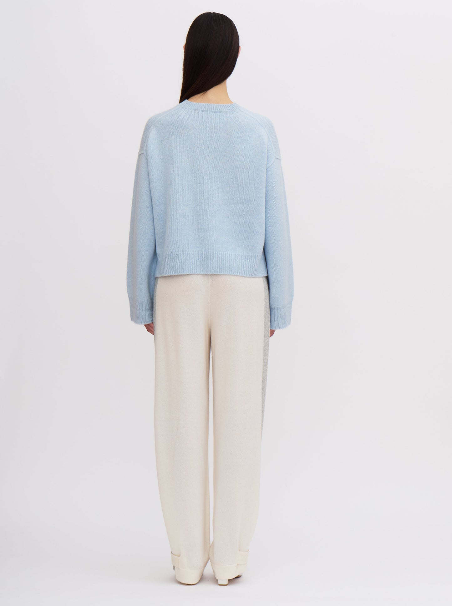 Light blue cropped cashmere sweater with cream trousers featuring grey side stripe.