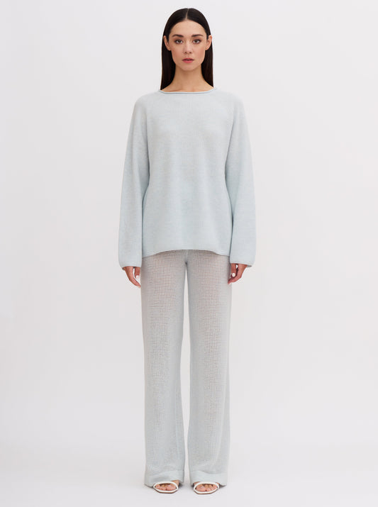 Front view of model wearing pastel blue light knit cashmere jumper and matching light blue wide leg cashmere pants.