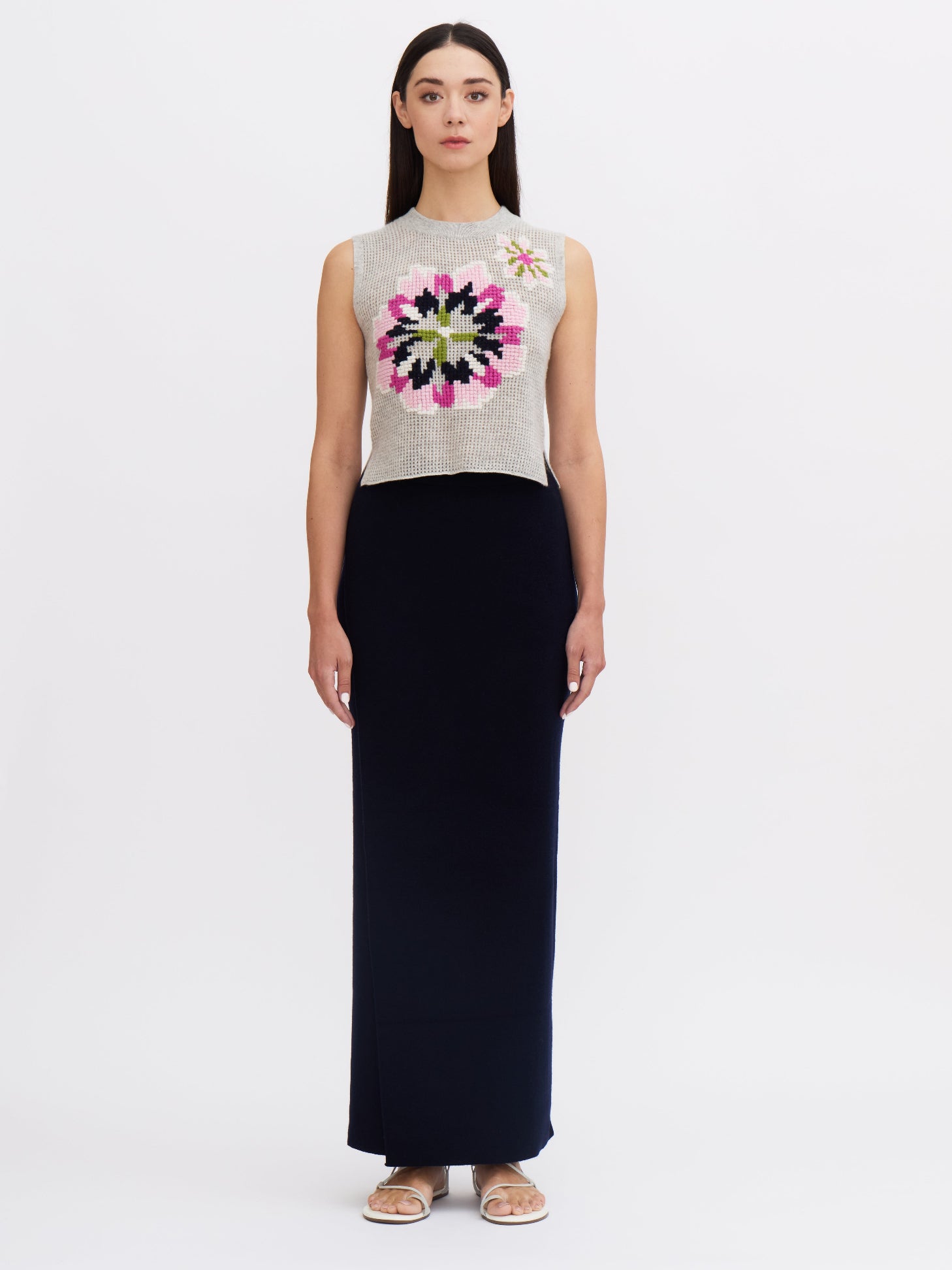 Front view of model wearing women's cashmere sleeveless floral embroidered top and navy cashmere maxi skirt.