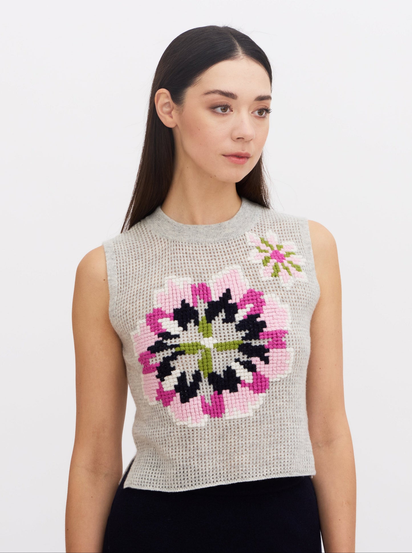 Close up of model wearing women's cashmere sleeveless floral embroidered top.