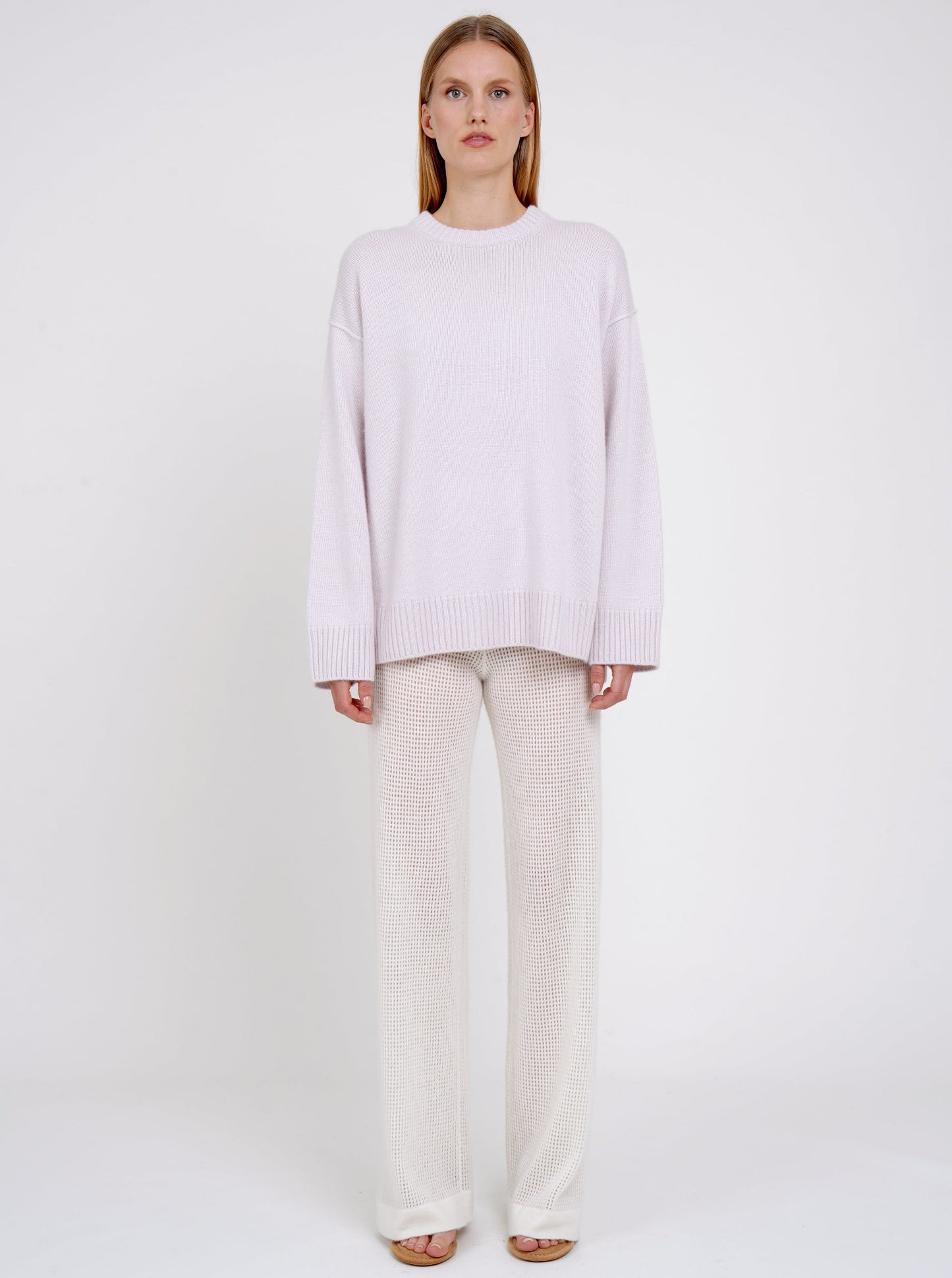 Front view model in pale purple long jumper with round neck, long sleeves and white cashmere knit pants.
