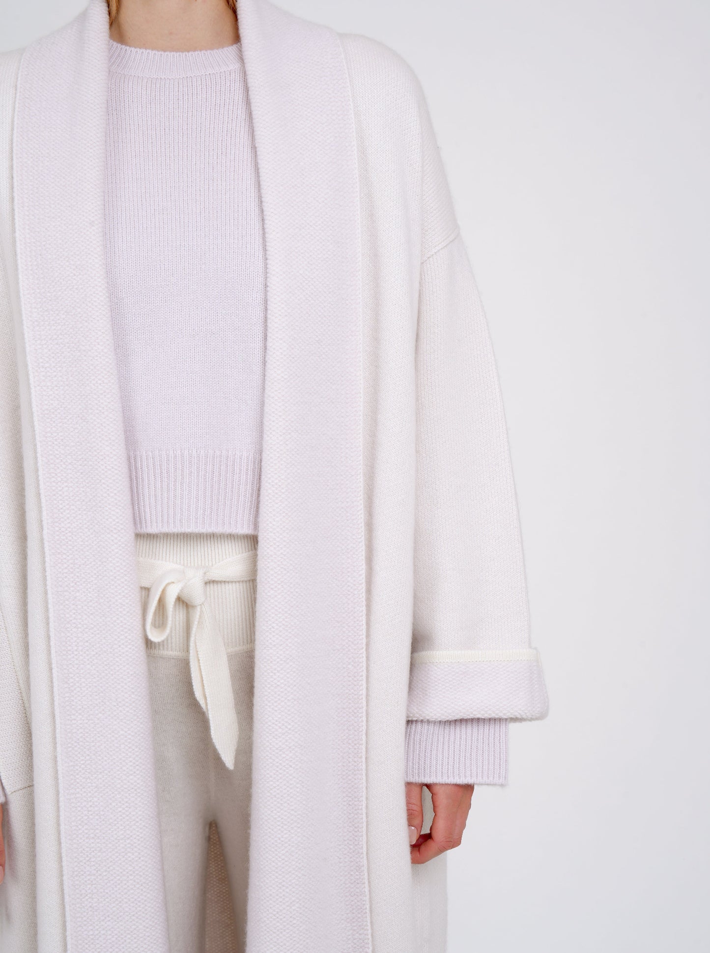 cropped detail of lilac and white cashmere long coat with fold back cuffs.
