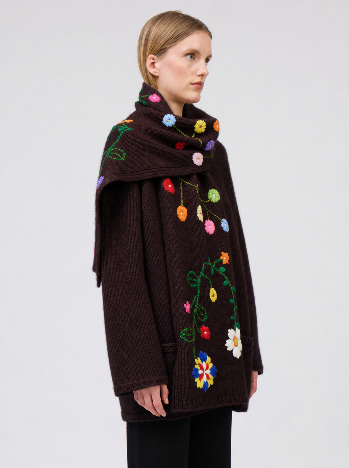 Side view model wearing mahogany brown cashmere hip-length jacket with brightly coloured hand-embroidered scarf.