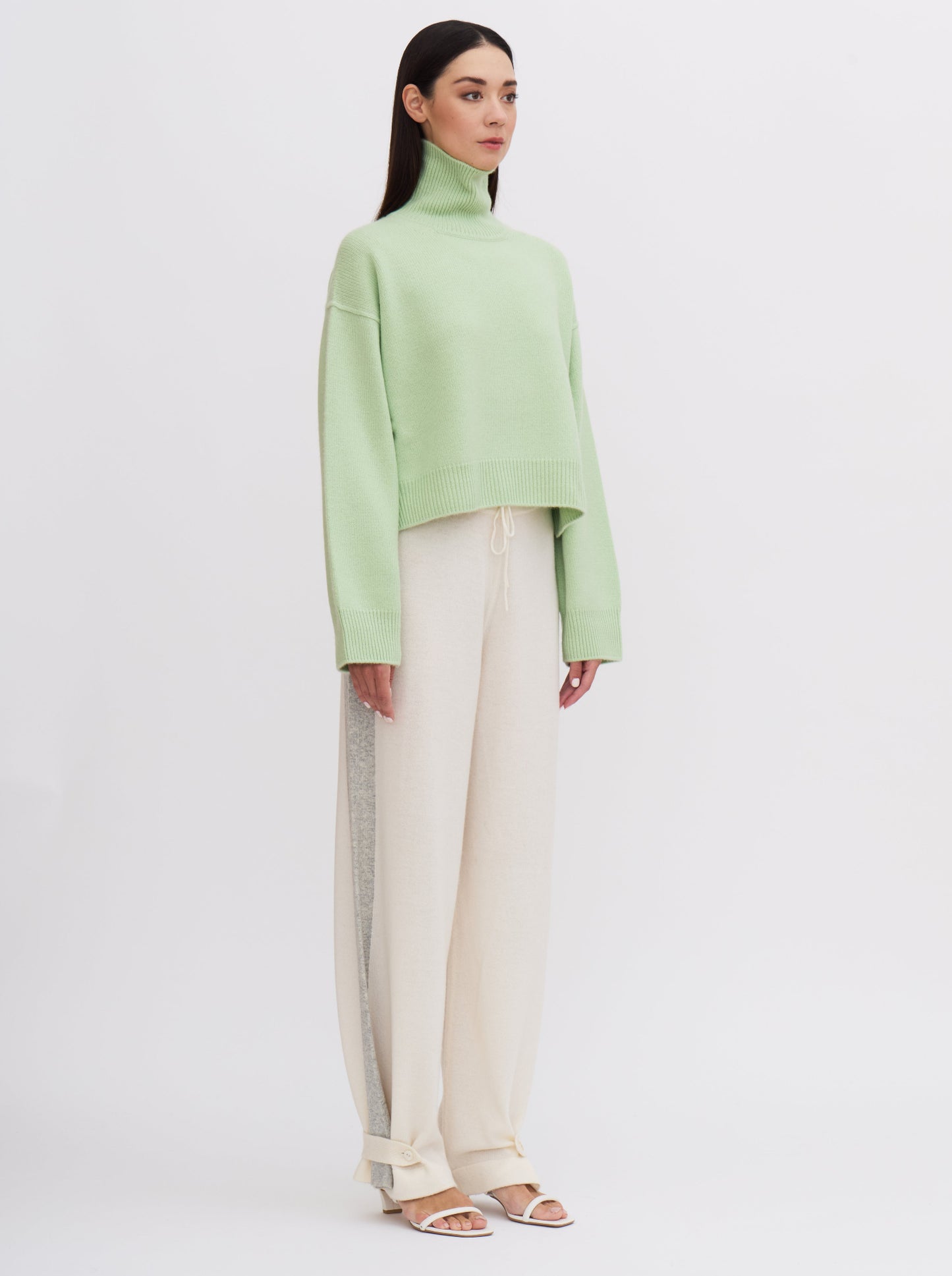 Mint green cropped cashmere jumper with cream trousers featuring grey side stripe.