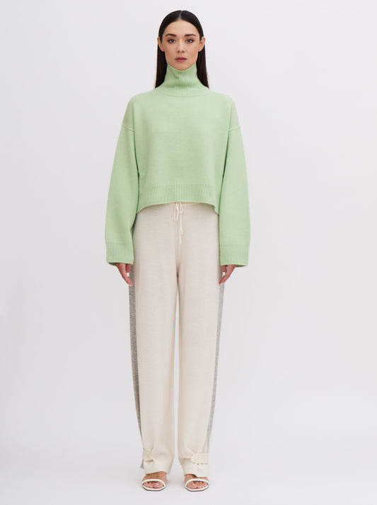 Mint green cropped cashmere sweater with cream trousers featuring grey side stripe.