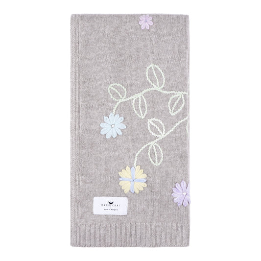 Beige knitted cashmere, square baby cost blanket, covered in pastel coloured hand embroidery of flowers and leaves.