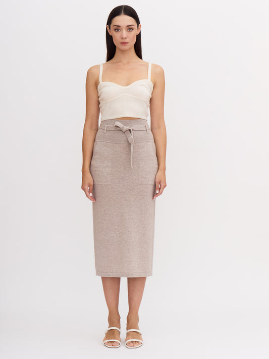 Front view of model wearing beige cashmere high waisted pencil skirt with tie belt.