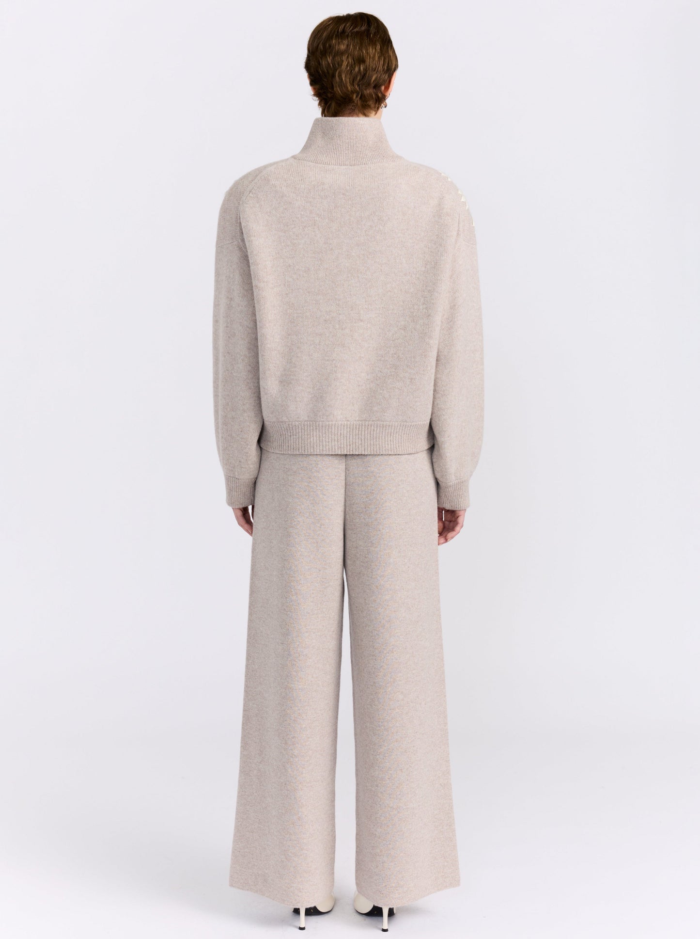 MANDKHAI new beige cashmere bomber jacket with hand-embroidered floral detailing, styled with matching wide-leg cashmere trousers.