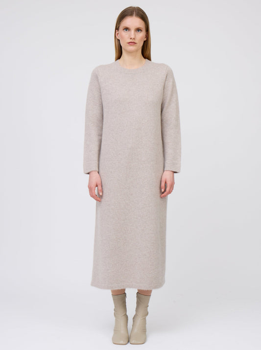 Front view of model wearing plain colour beige cashmere straight cut maxi dress with long sleeves and side slit.