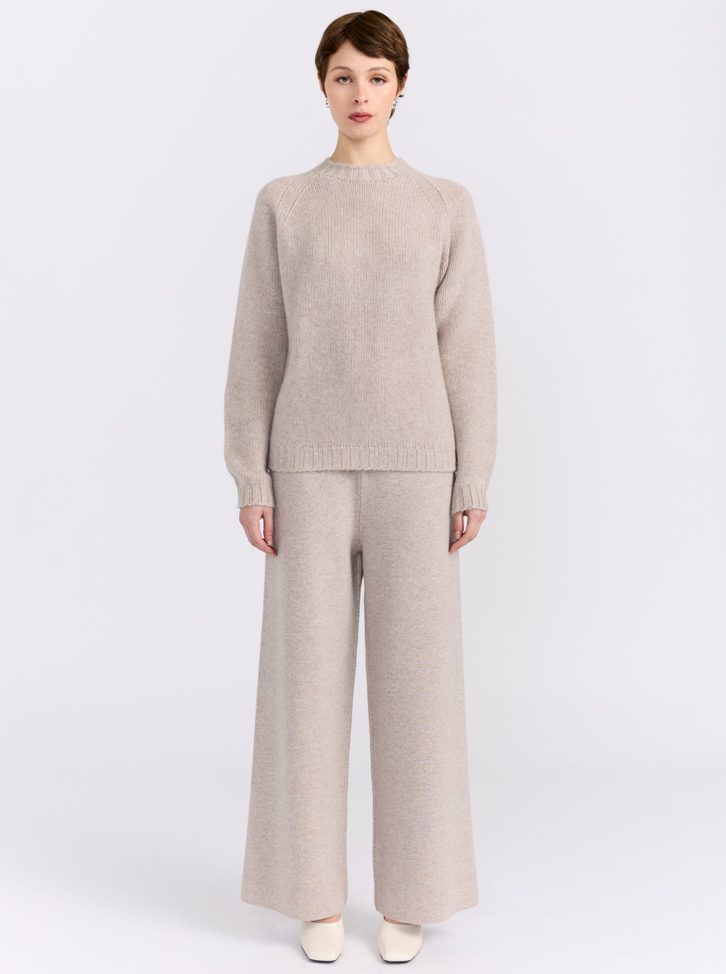 MANDKHAI new beige pure cashmere round neck sweater with raglan sleeves and a soft mink finish, styled with matching cashmere trousers.