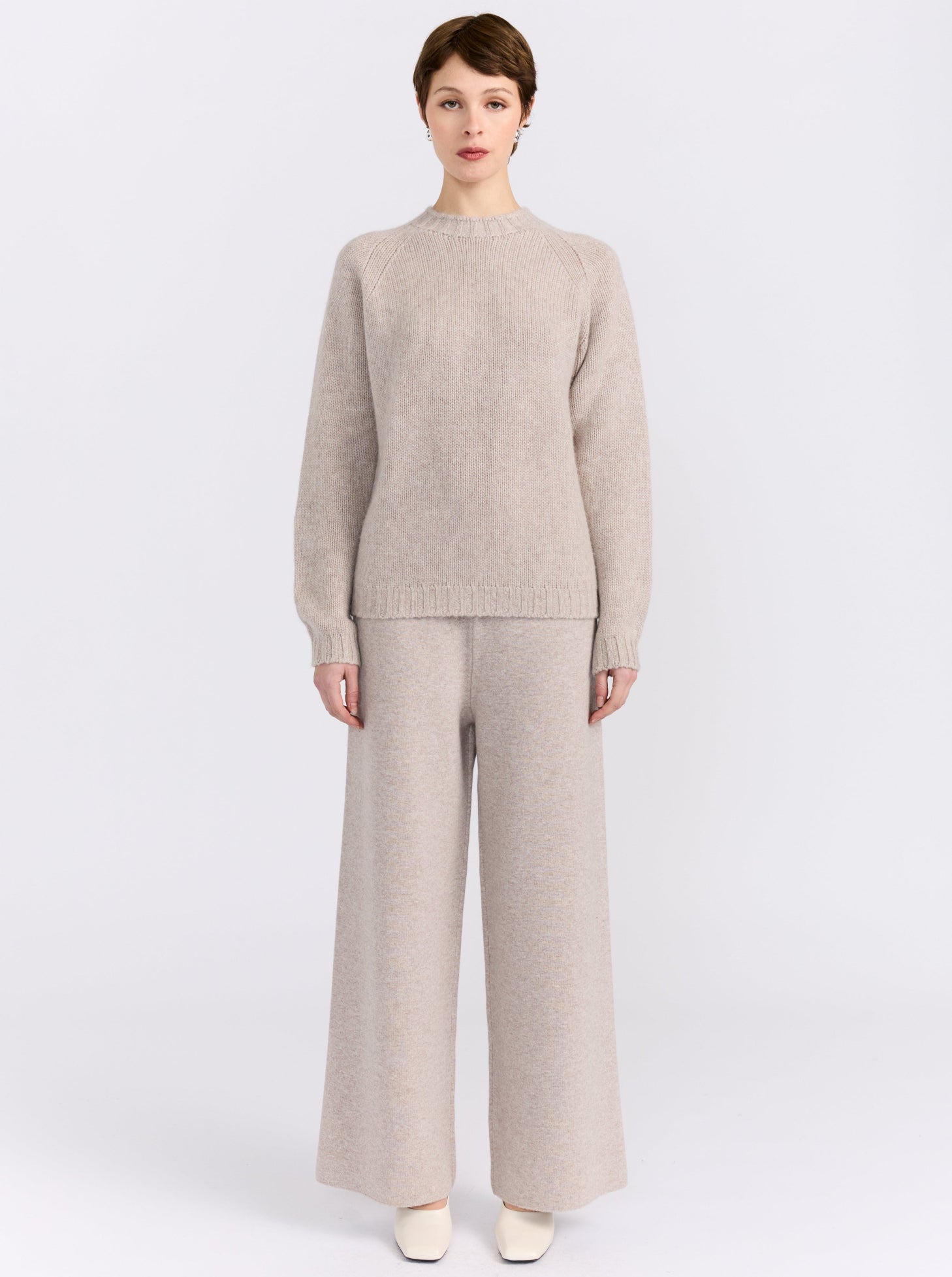 MANDKHAI new beige pure cashmere round neck sweater with raglan sleeves and a soft mink finish, styled with matching cashmere trousers.