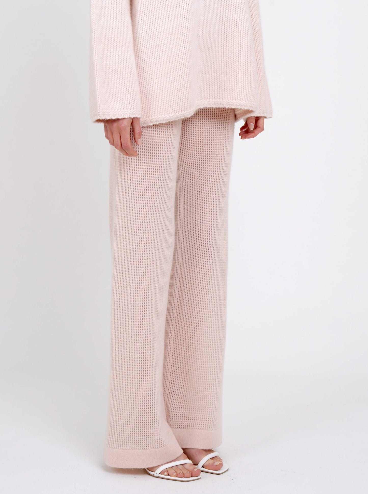 close up side view of peach colour net knit cashmere wide leg trousers