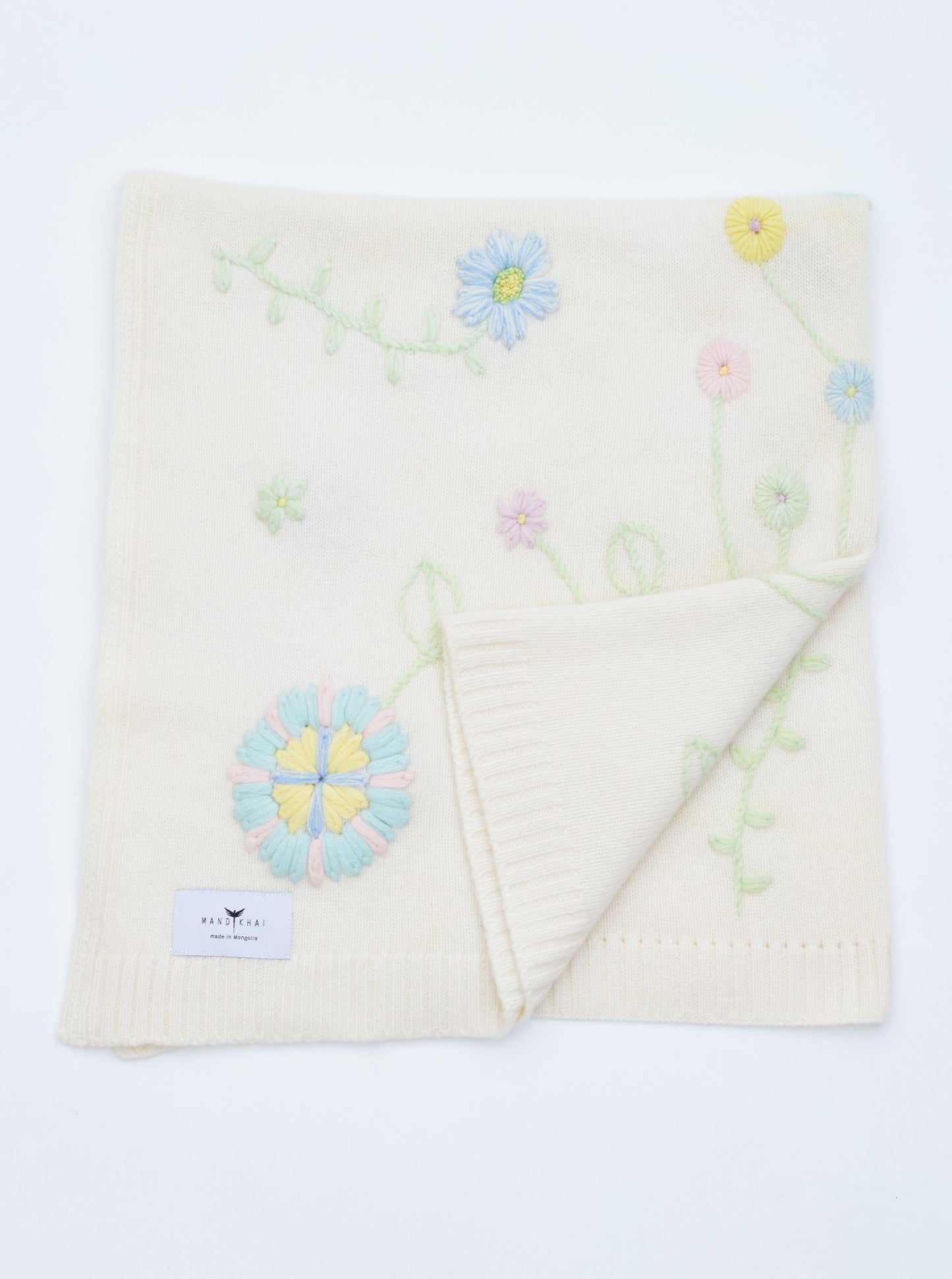 Front Flat Lay of the White Hand Embroidered Cashmere Baby Blanket with pastel colour flowers 