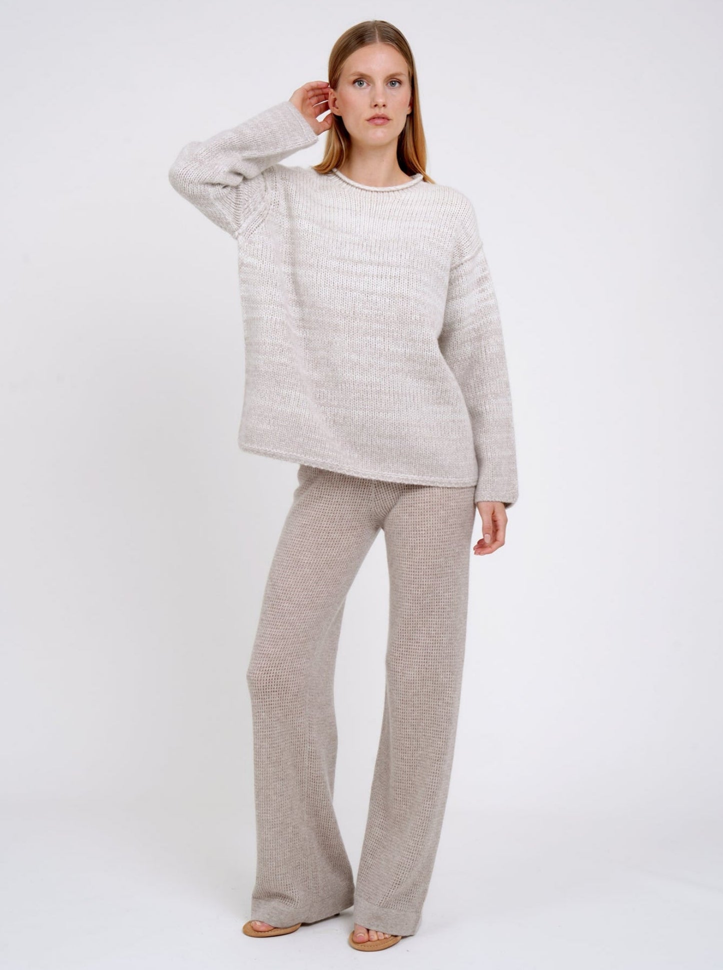 model wears a  relaxed fit mixed colour knitted jumper in natural white and beige, with round neck and long wide sleeves.