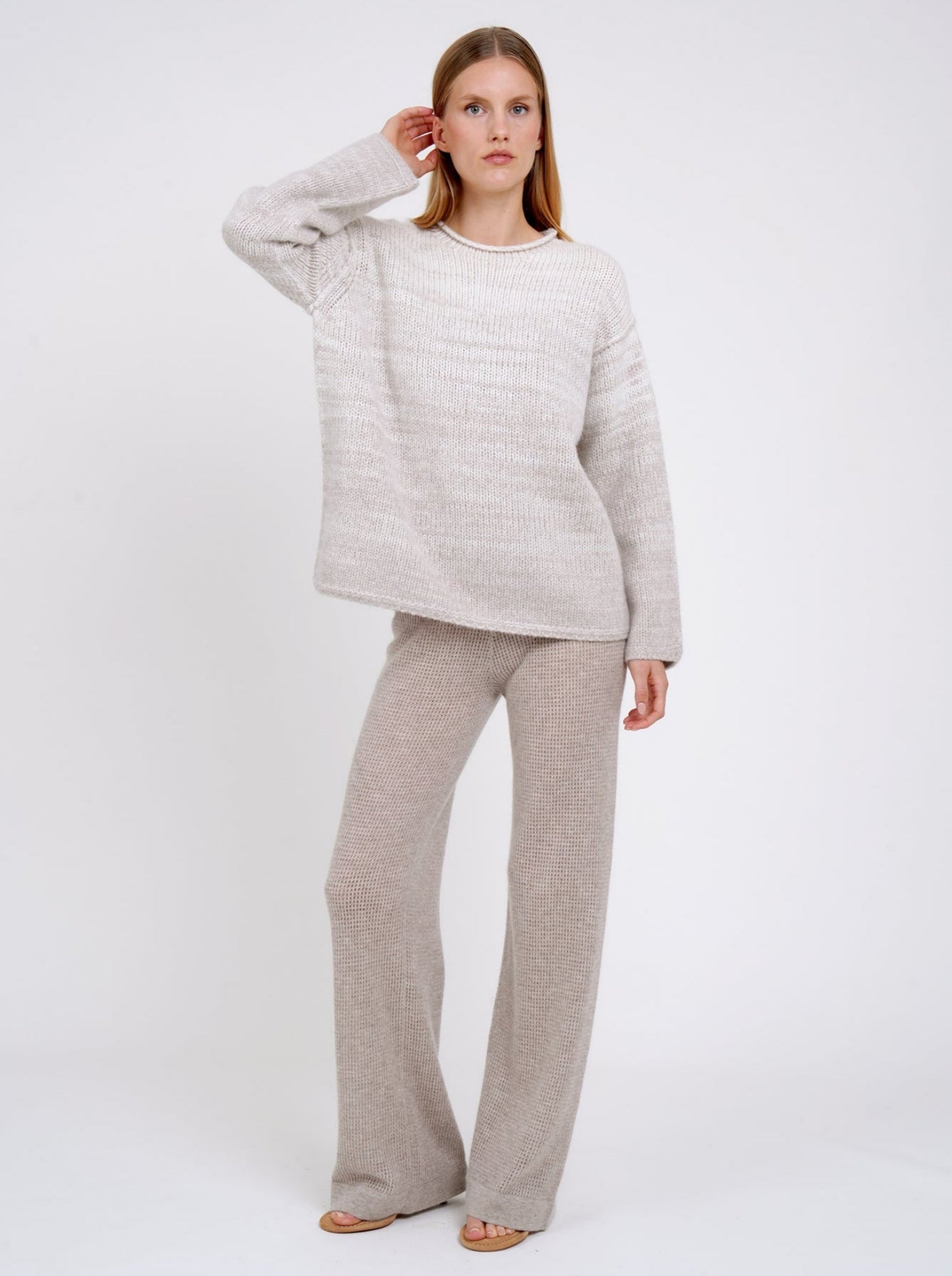 model wears a  relaxed fit mixed colour knitted jumper in natural white and beige, with round neck and long wide sleeves.