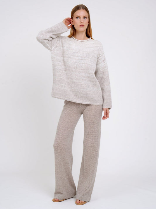 model wears a  relaxed fit mixed colour knitted jumper in natural white and beige, with round neck and long wide sleeves.