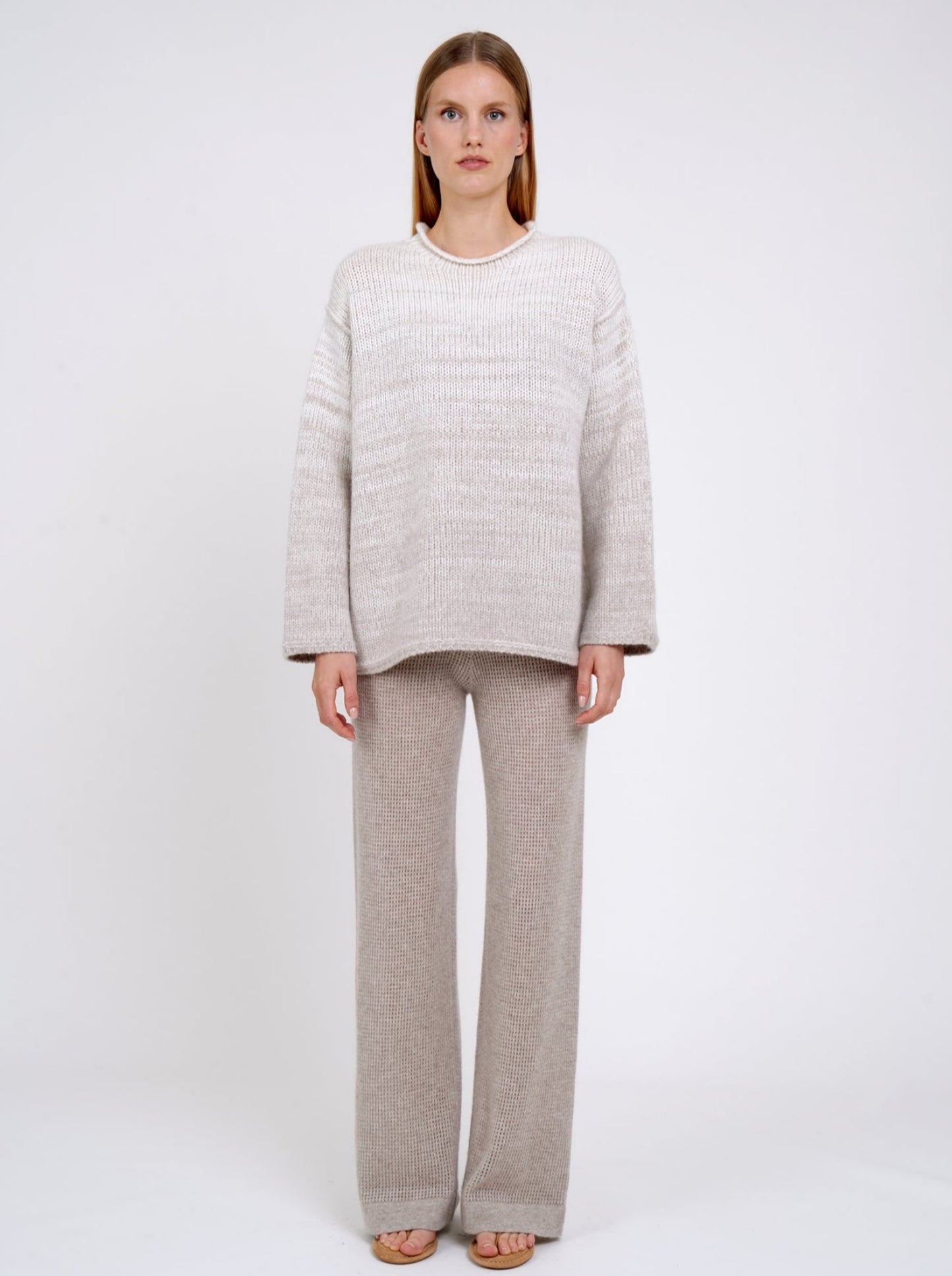 model wears a  relaxed fit mixed colour knitted jumper in natural white and beige, with round neck; worn with new beige cashmere knit pants.