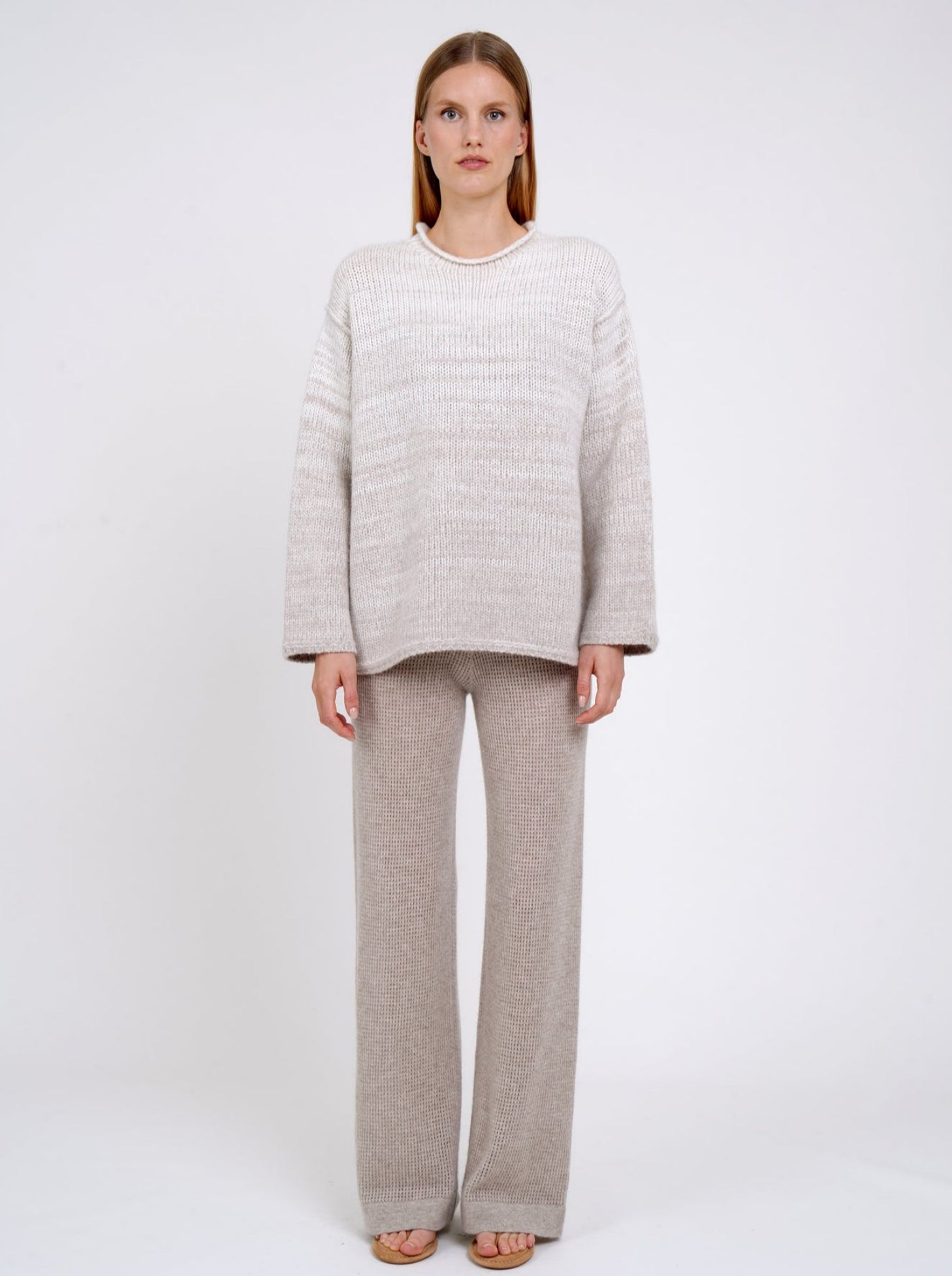 model wears a  relaxed fit mixed colour knitted jumper in natural white and beige, with round neck; worn with new beige cashmere knit pants.