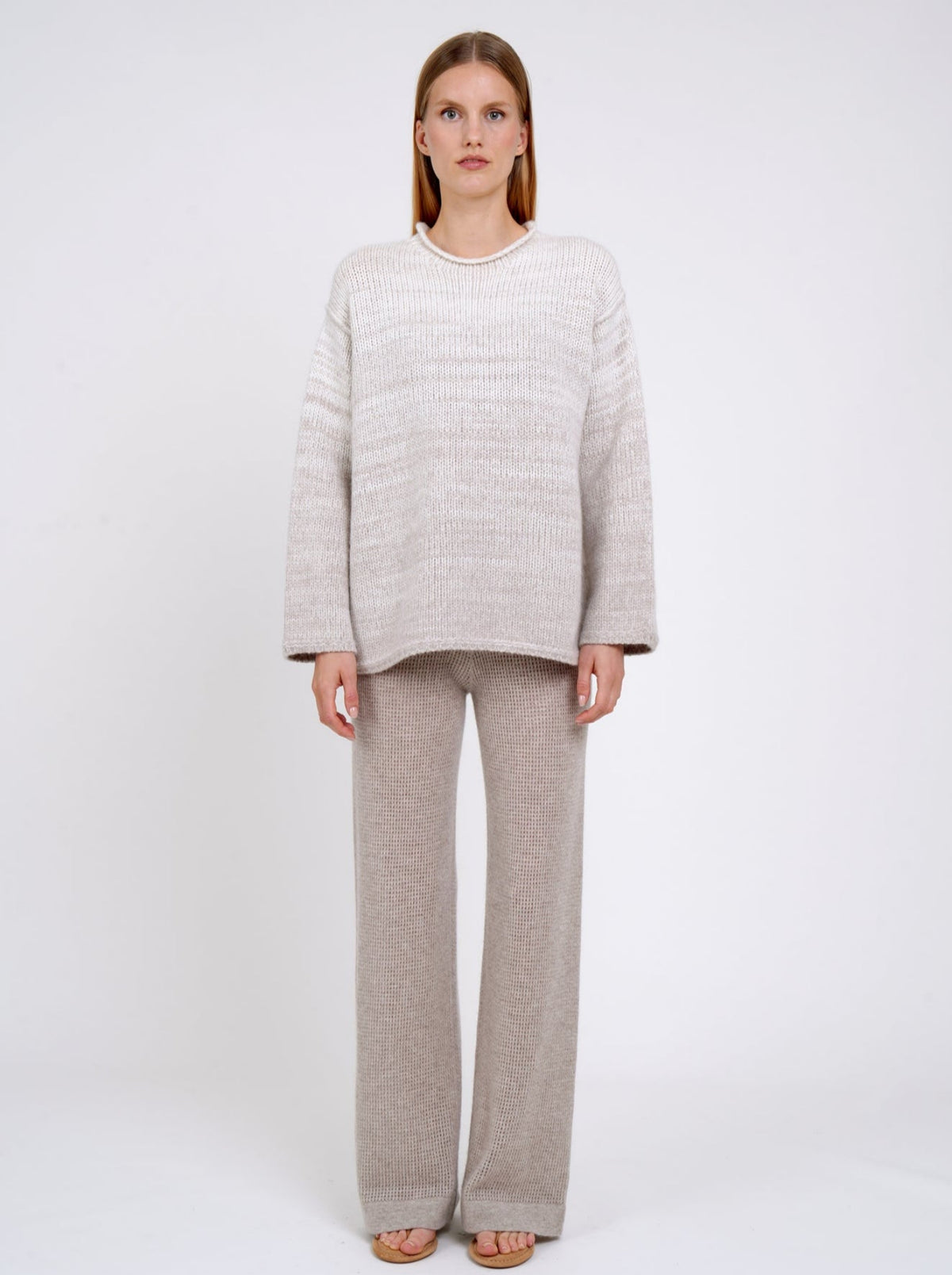 model wears a  relaxed fit mixed colour knitted sweater in natural white and beige, with round neck; worn with new beige cashmere knit pants.
